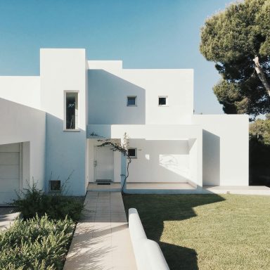 kundenorientierte Serviceleistung Bild zeigt weißen Bungalow im mediteranem Umfeld, mit gepflegter Außenanlage